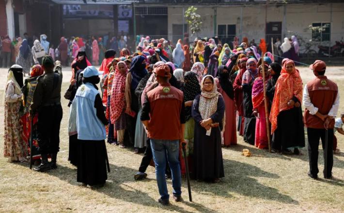 ناخبون يصطفون للإدلاء بأصواتهم أمام أحد مراكز الاقتراع في دكا (رويترز)