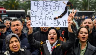 رفعت متظاهرة لافتة كُتب عليها "كل شعرة في رؤوسنا ثمينة كالعالم أجمع"، مع ضفيرة شعر مُعلقة بها، وهي تُردد شعارات خلال مظاهرة تضامنية مع الأكراد في شمال سوريا، في إسطنبول، بتاريخ 24 يناير/كانون الثاني 2026. AFP - YASIN AKGUL