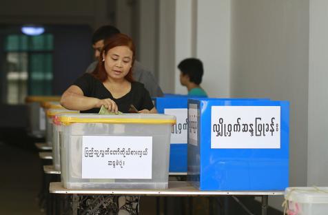 A woman places her ballot into the Pyithu Hluttaw representative election box in the April 2012 by-elections.