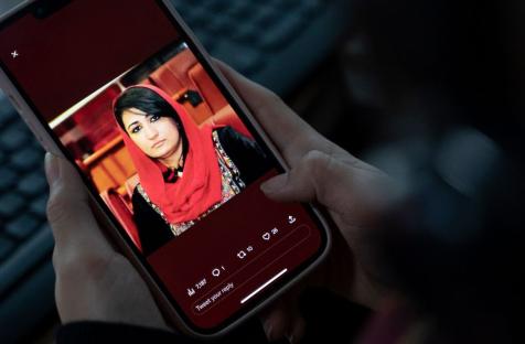 A woman looks at a picture of former Afghan lawmaker Mursal Nabizada on her mobile phone, who was shot dead by gunmen at her house in Kabul on January 15, 2023.
